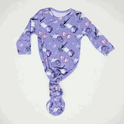 Purple baby onesie with music-themed design on a white background