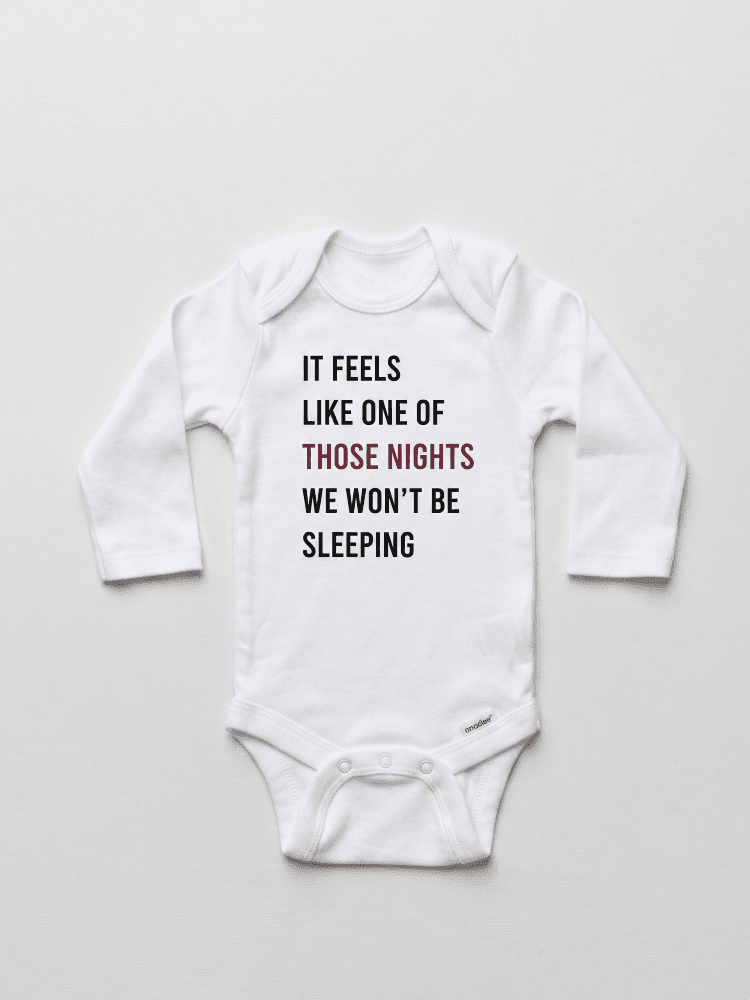 White baby onesie with text on a light gray background