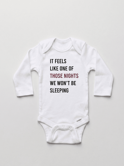 White baby onesie with text on a light gray background