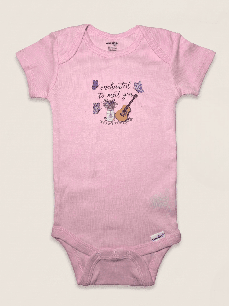 Pink baby onesie with a printed design on a light beige background