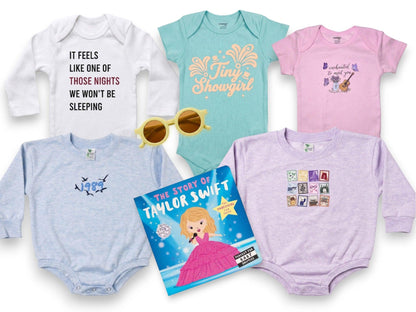 Collection of baby onesies with various designs and a book titled 'The Story of Taylor Swift' on a white background.