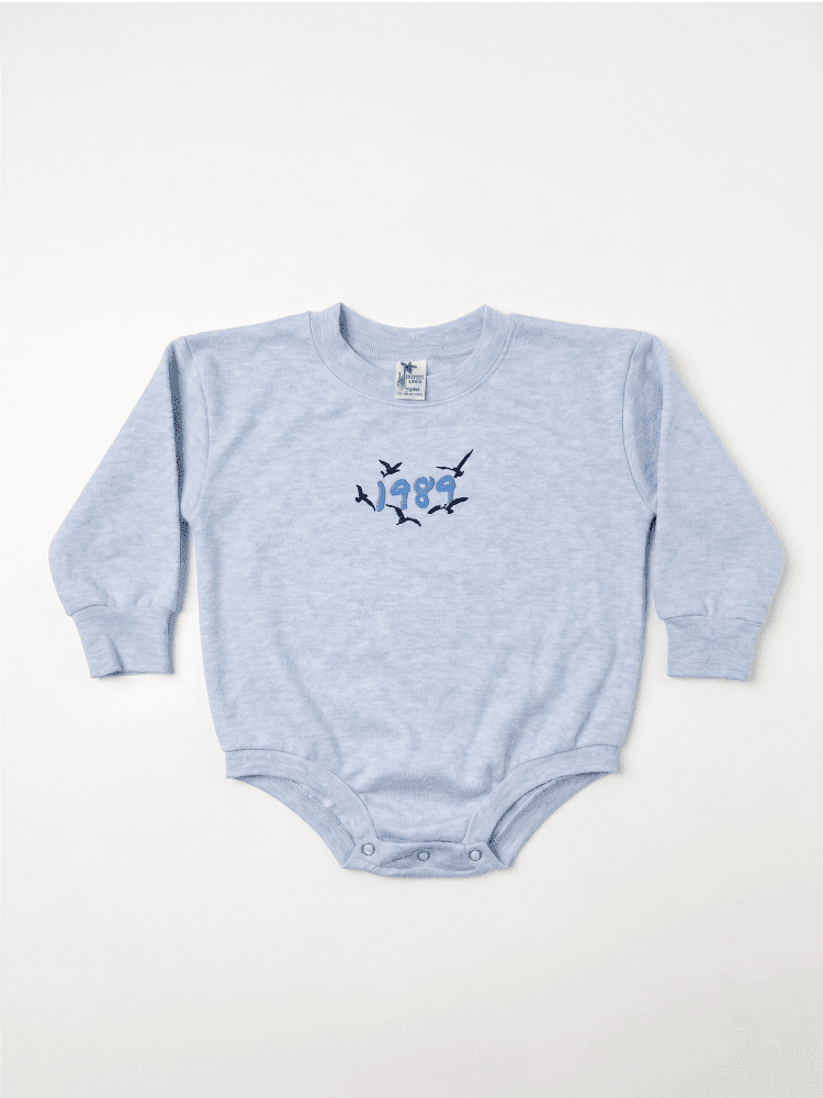 Light blue baby onesie with a design on a white background