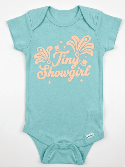 Light blue baby onesie with 'Tiny Showgirl' text in orange on a white background