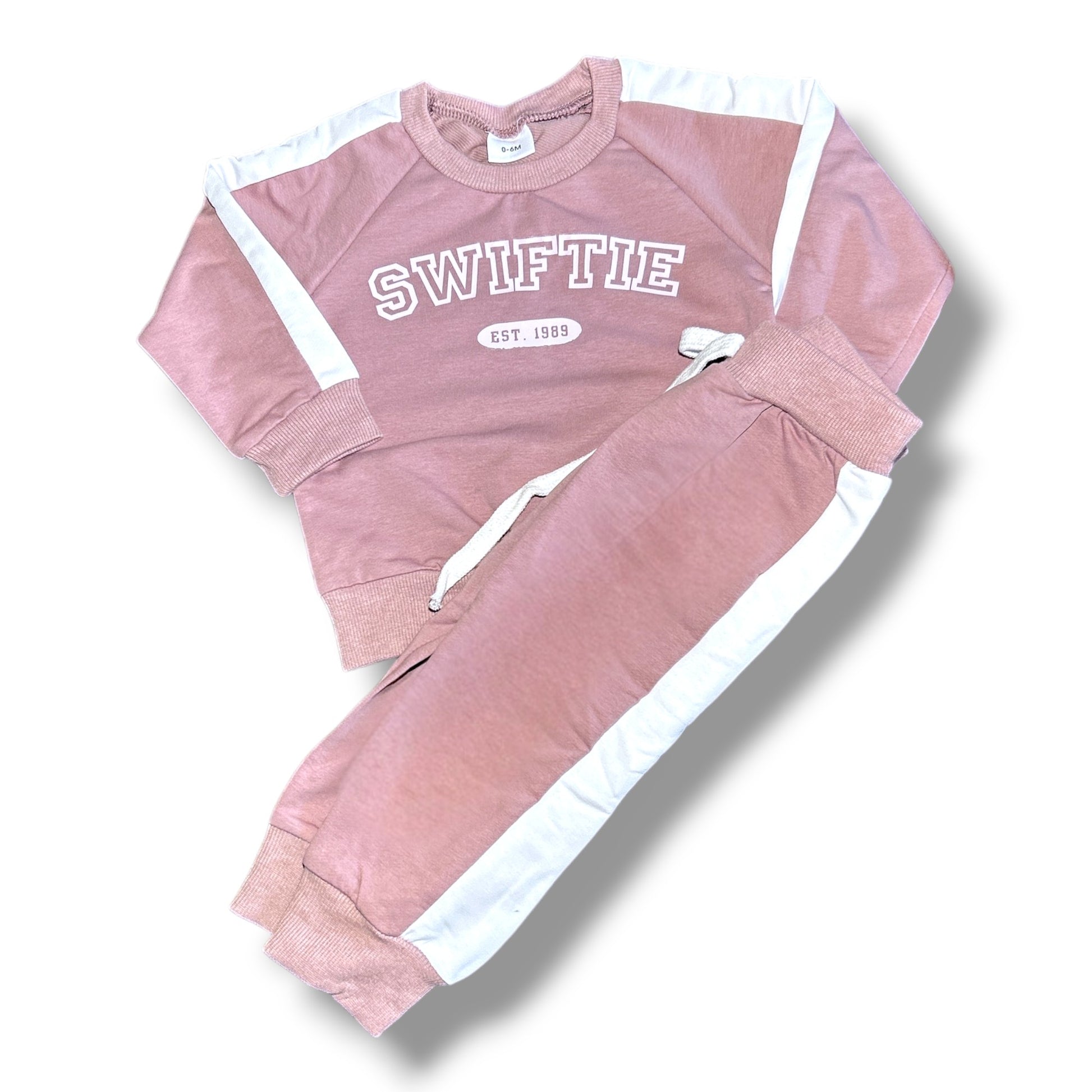 Pink 'SWIFTIE' tracksuit with white accents on a white background