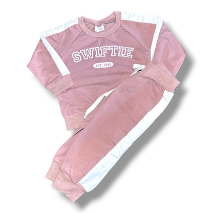 Pink 'SWIFTIE' tracksuit with white accents on a white background
