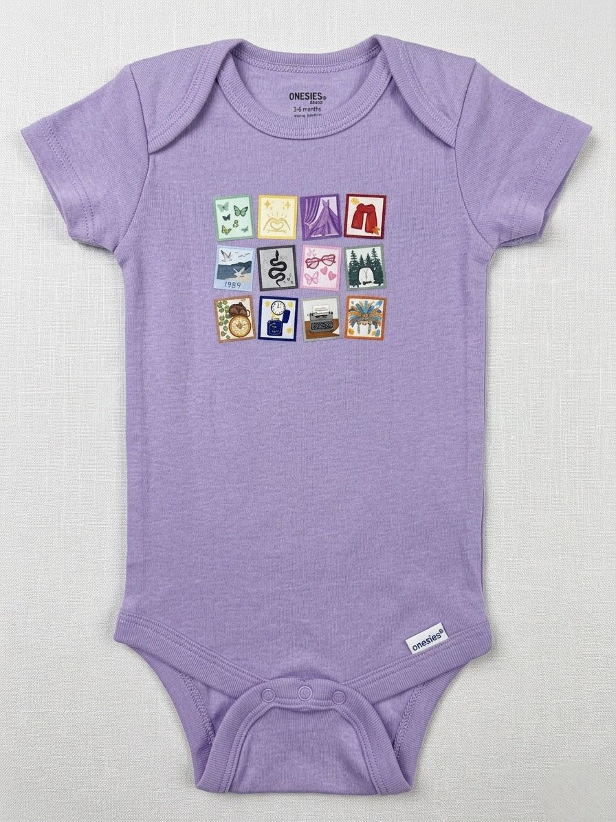Purple baby onesie with colorful graphic on a light gray background