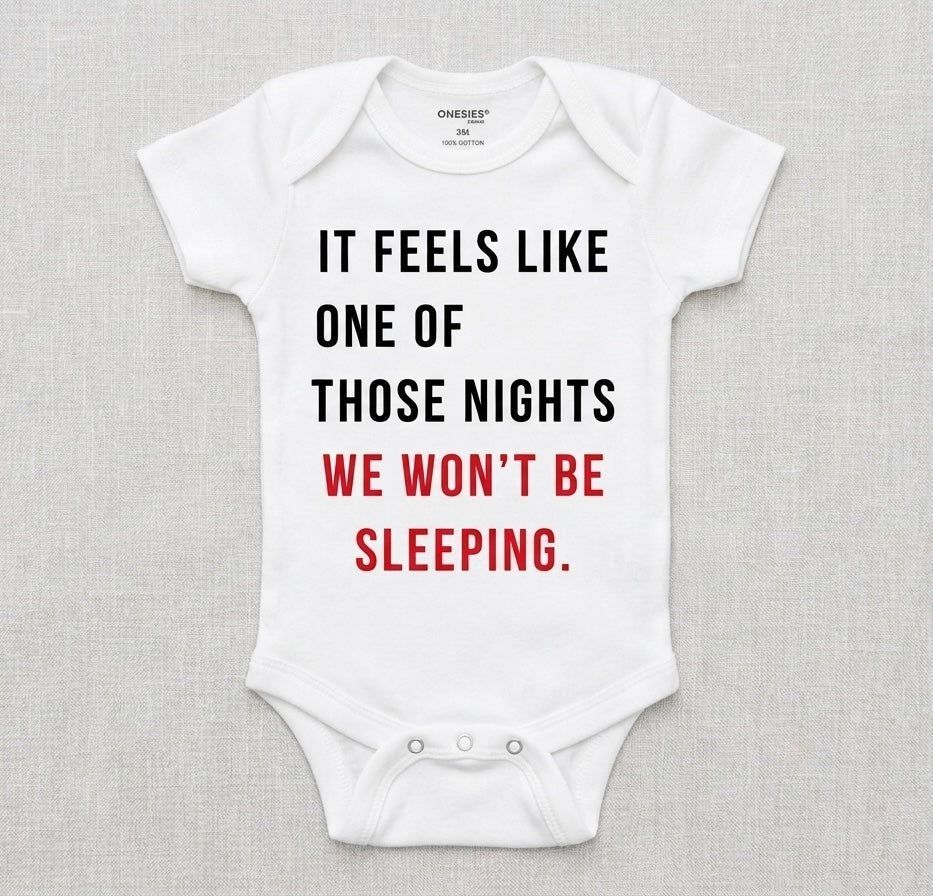 White baby onesie with humorous text on a gray background