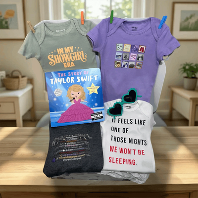 Collection of baby clothes and a book on a table with a home setting in the background