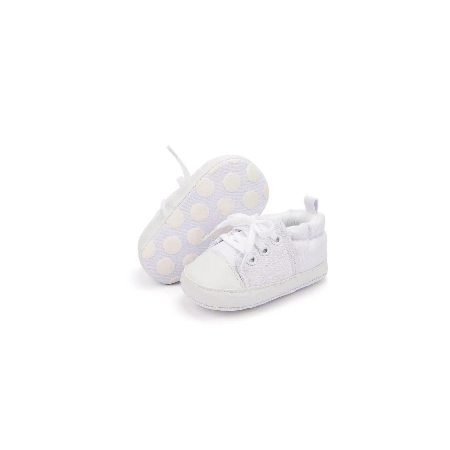 White baby shoes with polka dot socks on a white background