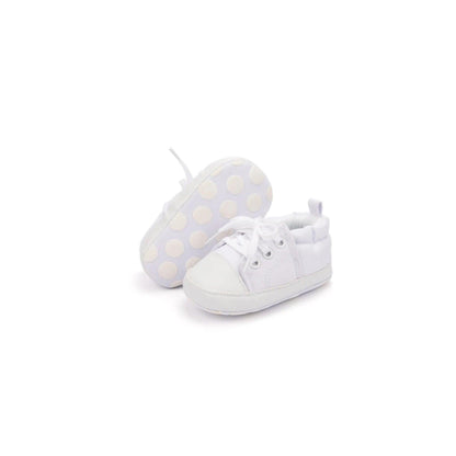 White baby shoes with polka dot socks on a white background