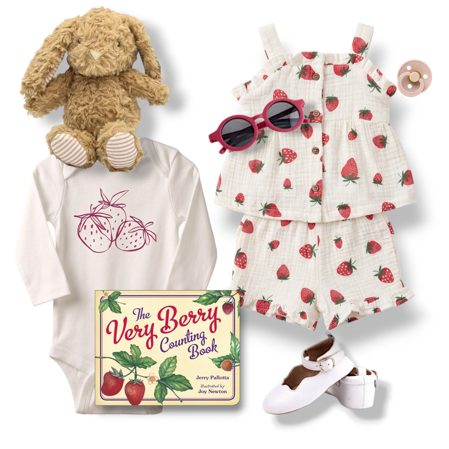 Baby outfit with strawberry-themed dress, onesie, and book, accompanied by a plush toy and pacifier.