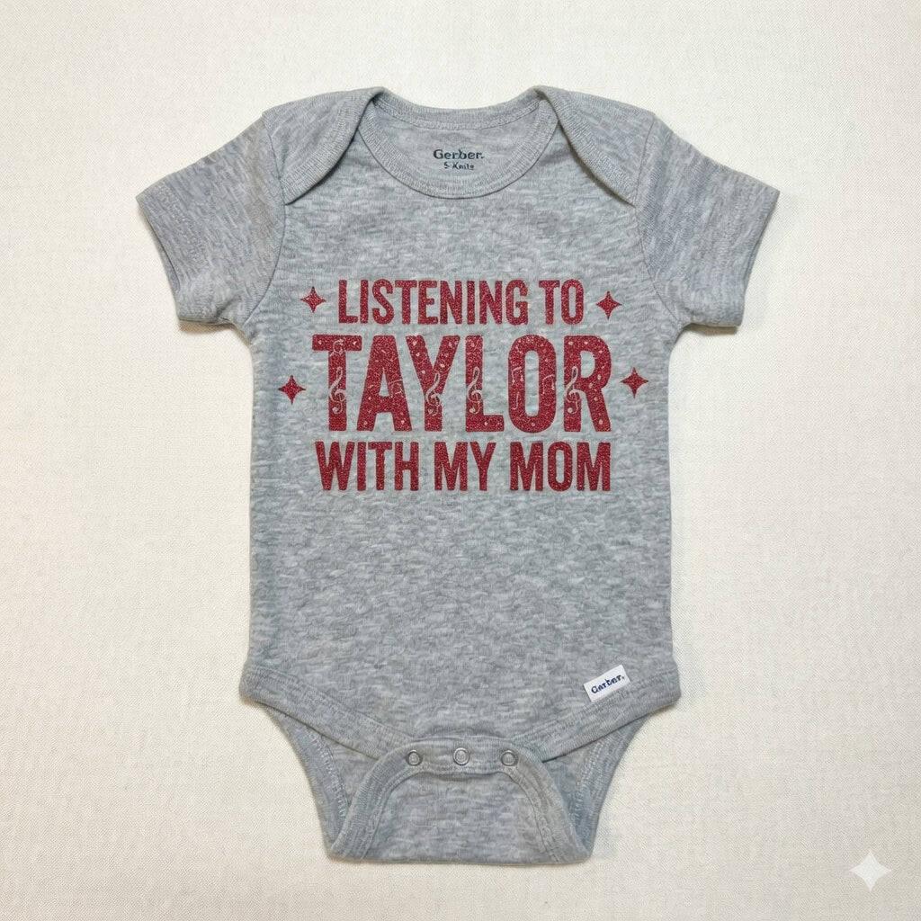 Gray baby onesie with red text 'Listening to Taylor with my mom' on a beige background