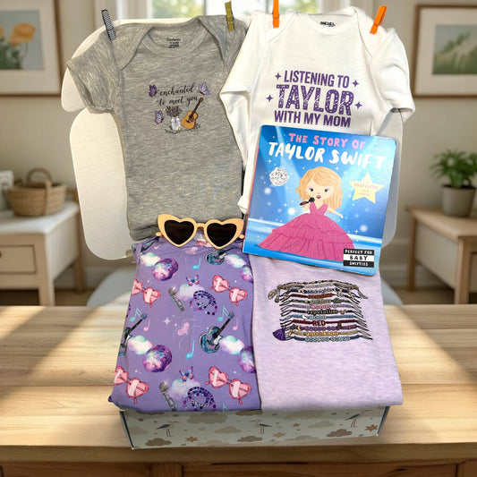 Collection of children's clothing and a book on a wooden surface with a home setting in the background.