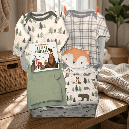 Baby clothing set with forest-themed designs on a wooden surface.